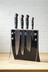 4 knives safely organized in an acrylic see-through knife block setting on a counter top