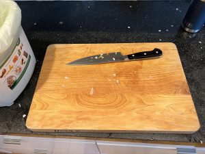 Knife on cutting board with edge pointing away