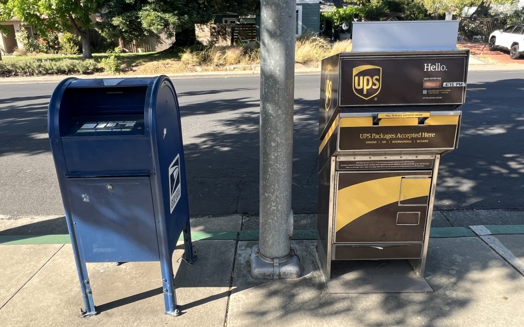 A UPS Drop Box next to a USPS Mailbox, curb-side