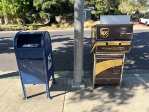A UPS Drop Box next to a USPS Mailbox, curb-side
